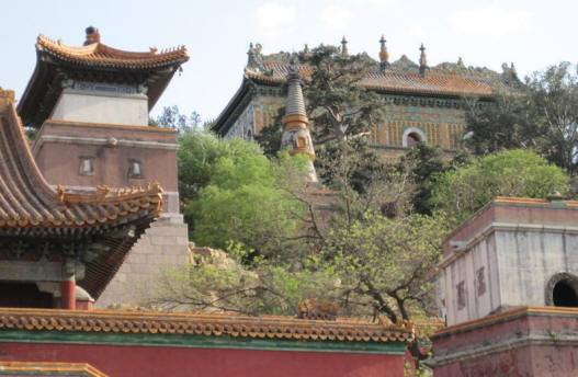 Green and yellow Temple of the Sea of Wisdom covered in small Buddhas behind the Four Great Regions