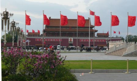 The National Flag stands tall in front of Mao's picture.